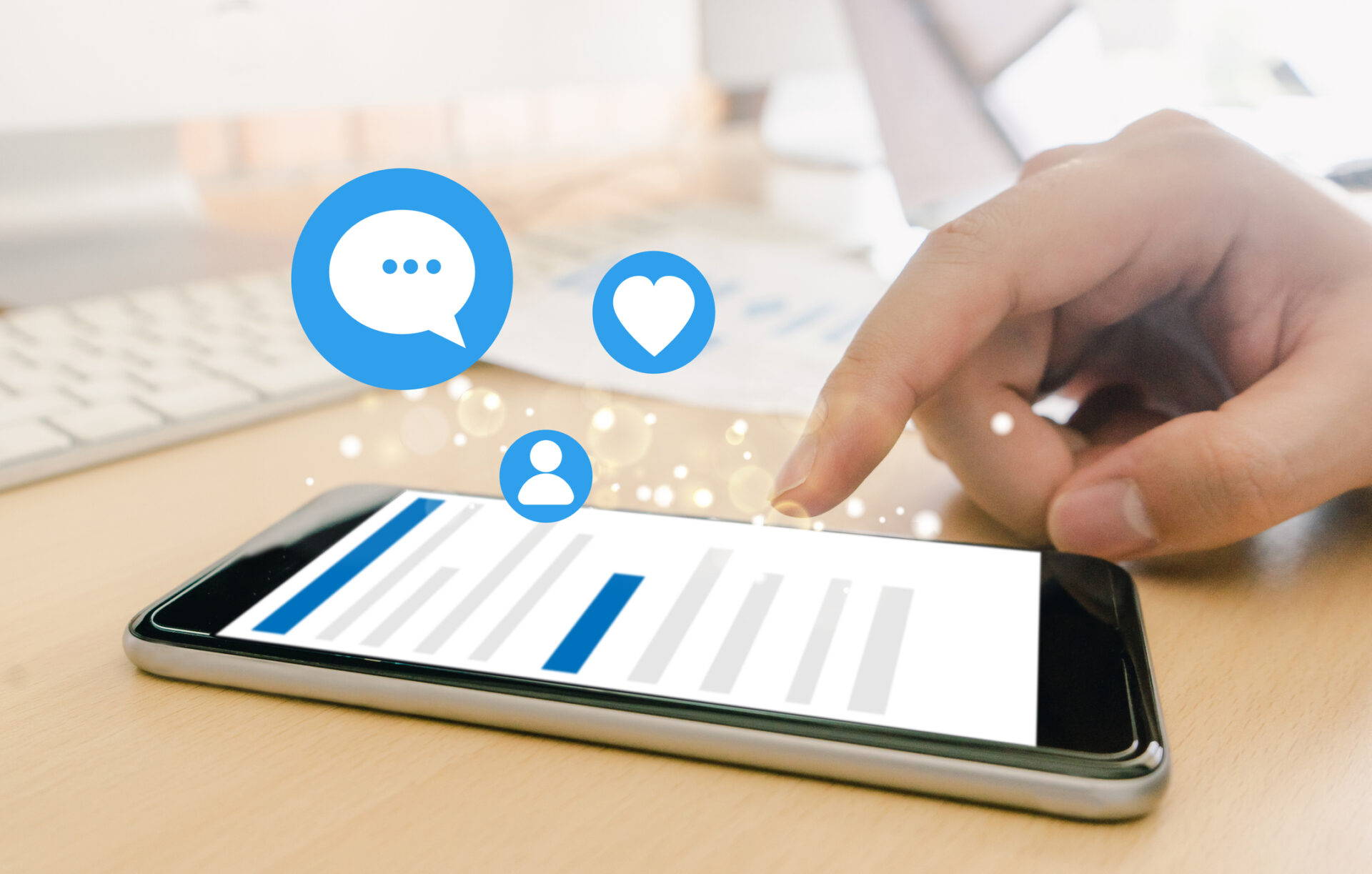 Na zdjęciu widać dłoń i smartfon z emotikomani