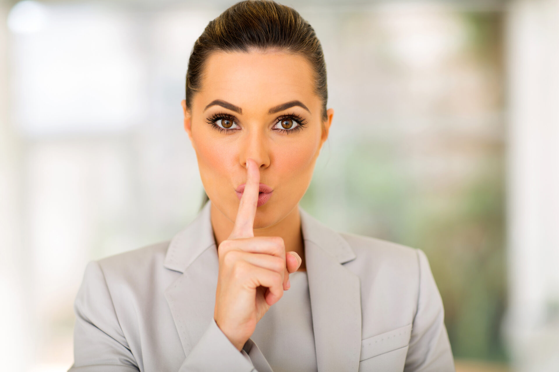 Na zdjęciu kobieta wykonuje gest uciszania