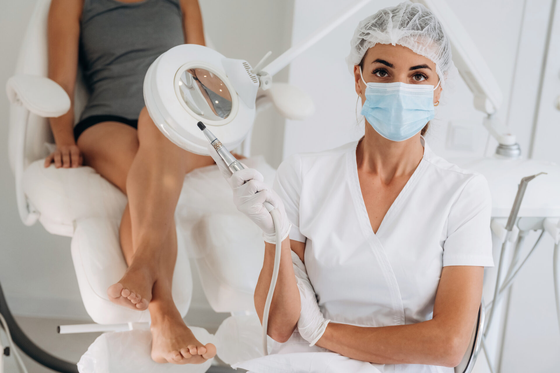 Srebrny profesjonalny sprzęt do peelingu. Podolog z klientem w klinice