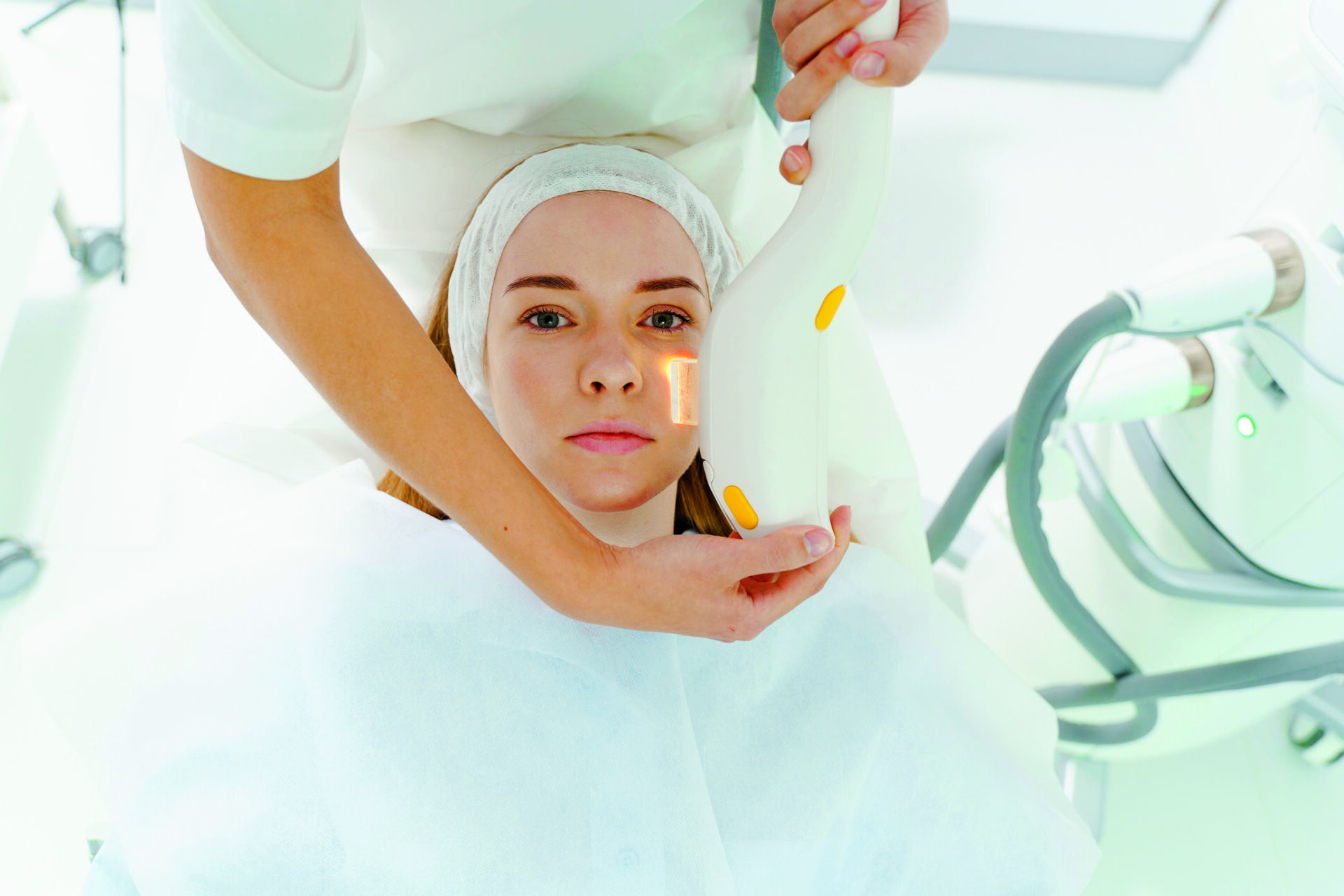 Laserowa terapia trądziku i przebarwień twarzy. Pielęgnacja skóry z bliznami potrądzikowymi przez kosmetyczkę. Laserowe leczenie trądziku na twarzy kobiety w gabinecie kosmetycznym.