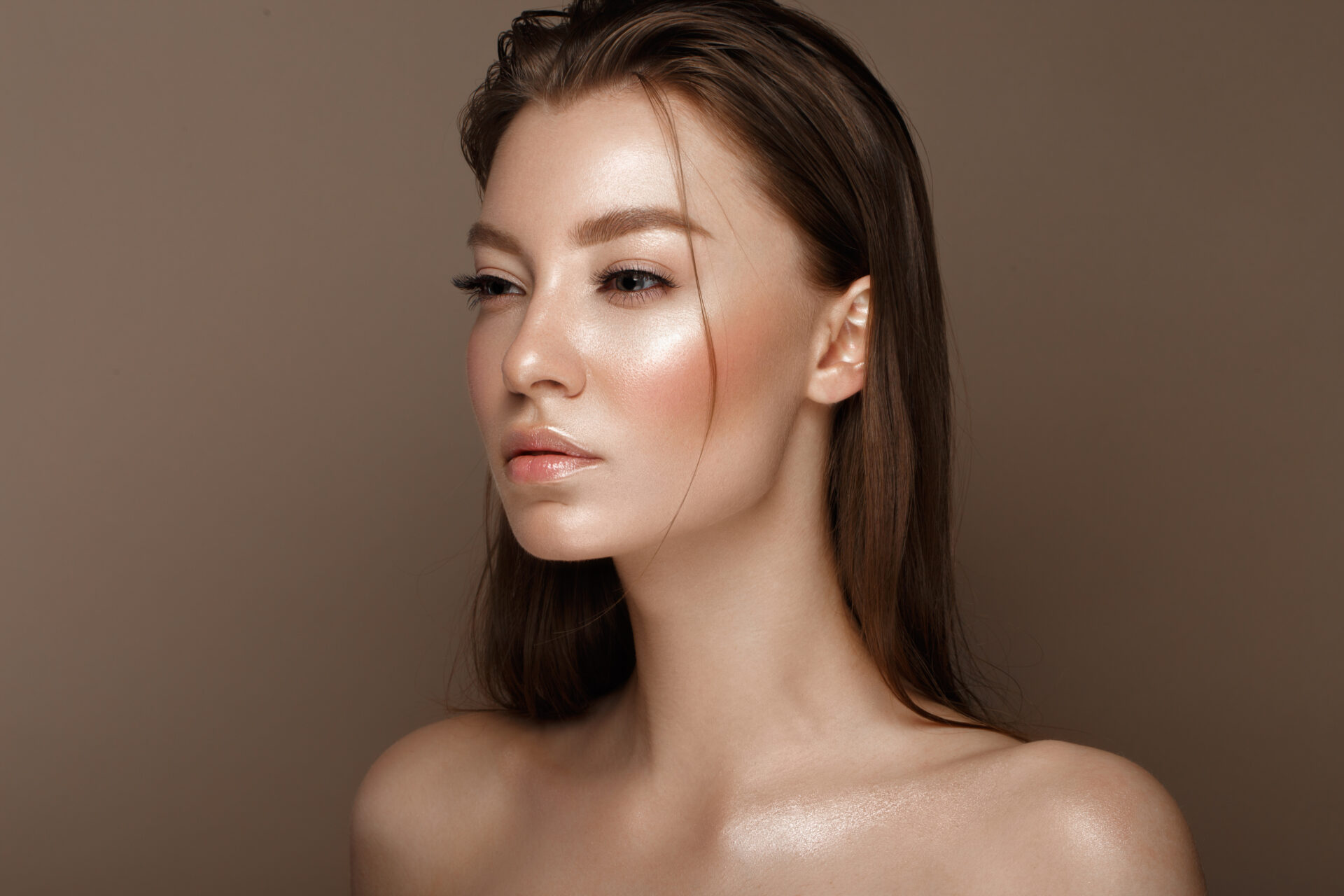 Piękna młoda dziewczyna z naturalnym makijażem w stylu nude. Piękna twarz. Zdjęcie wykonane w studiu